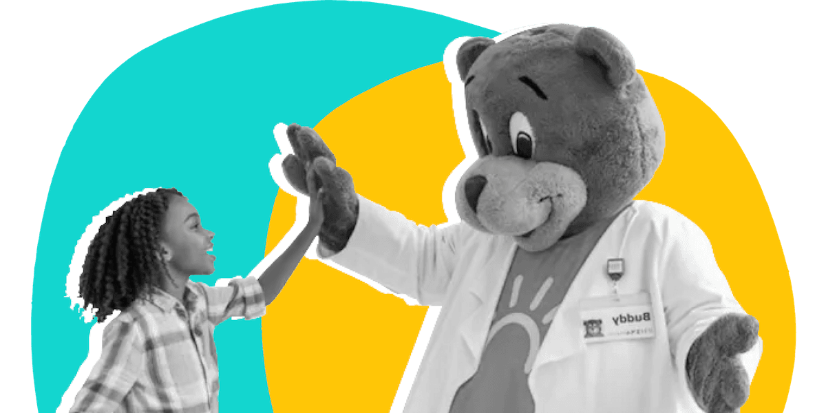 A little girl high fives a bear mascot