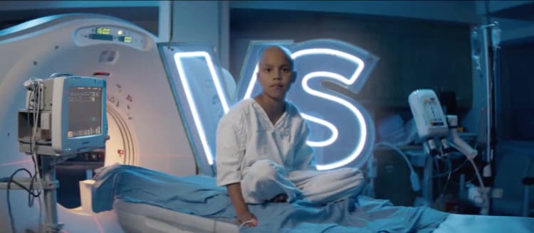 A child is sitting on the bed of an MRI machine