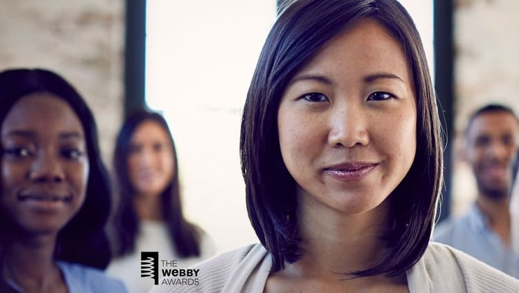 Asian woman in foreground smiling with three people blurred in background