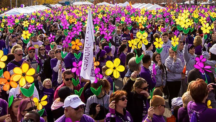Large Crowd Of People Holding ALZ Flowers Wearing Matching Purple Sweatshirts